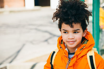 Close-up portrait of smiling schoolboy looking away