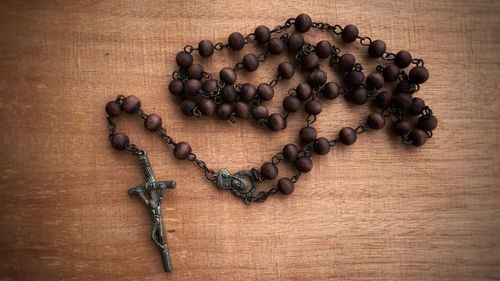 High angle view of holy rosary on wooden table