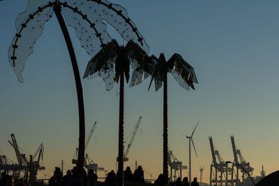 Low angle view of silhouette palm trees against sky at dusk