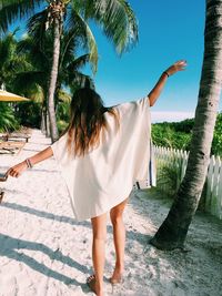 Woman standing on tree trunk