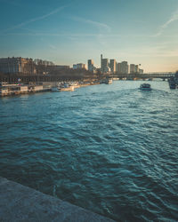 Sea by buildings against sky in city