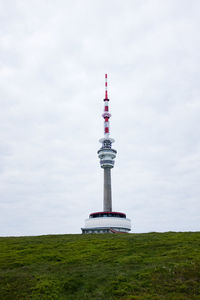 View of communications tower and buildings against sky. praded.