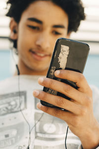 Teenage boy using mobile phone in city