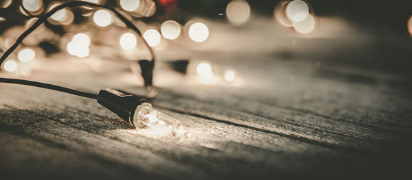 Close-up of string lights on wooden table