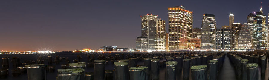 Illuminated buildings in city against sky at night