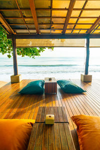 Lounge chairs by swimming pool at beach against sky