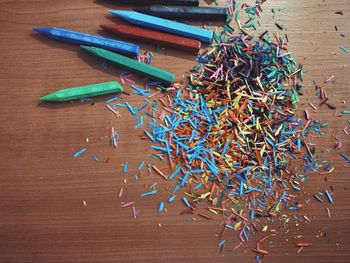 Directly above view of colorful crayon shavings on table