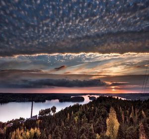 Calm lake against cloudy sky