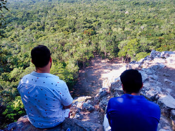 Rear view of man and woman looking at forest