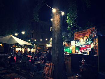 Illuminated street market in city at night