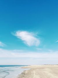 Scenic view of beach against blue sky
