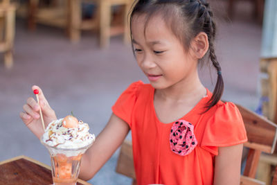 Cute girl having ice cream in restaurant