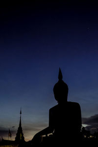 Silhouette of statue against sky at sunset