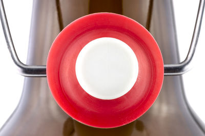A macro shot of the neck of a reusable bottle with a open ceramic cap, isolated on a white.