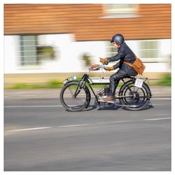 Side view of man riding bicycle on road