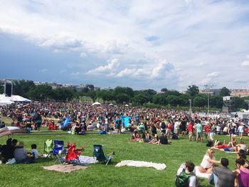 Crowd at music concert against sky