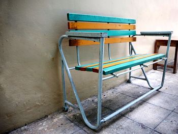 Empty chair on table against wall