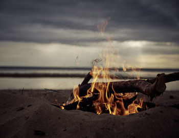 Low angle view of bonfire at dusk on beach