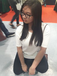 Young woman crouching on floor