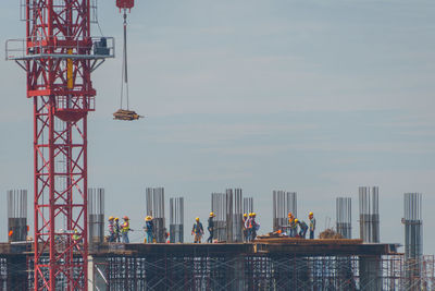 People at observation point by cityscape against sky