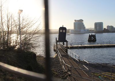 Scenic view of river by buildings against sky