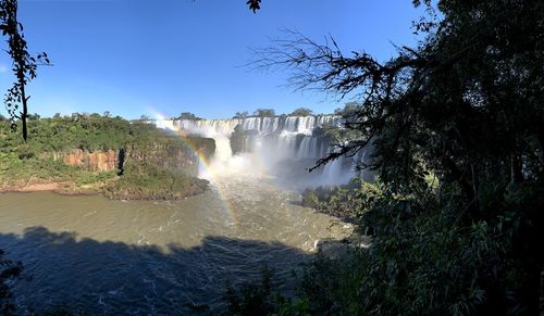 Scenic view of waterfall against sky