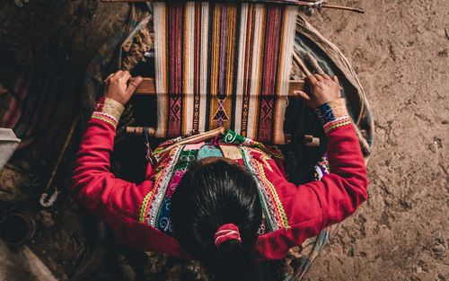 Rear view of man holding woman sitting outdoors