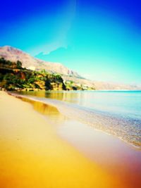 Scenic view of beach against clear blue sky