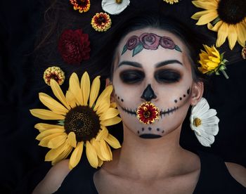 Woman with painted face amidst flowers