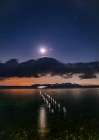 Scenic view of lake against sky at night