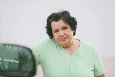 Portrait of woman standing against blurred background