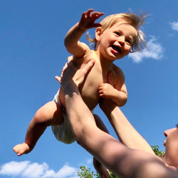 Low angle view of mother and child against sky