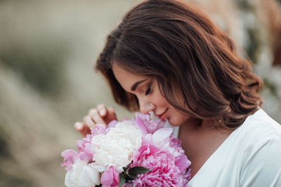 Portrait of woman holding pink flower