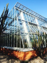 Low angle view of greenhouse against clear sky