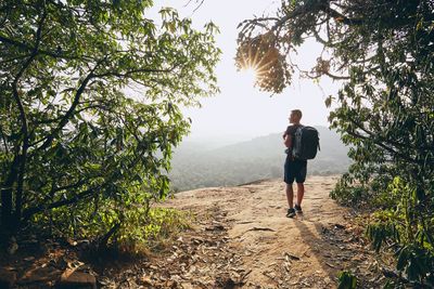 Man walking on footpath against land