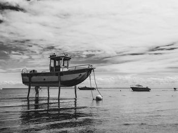 Fishing boats in sea against sky