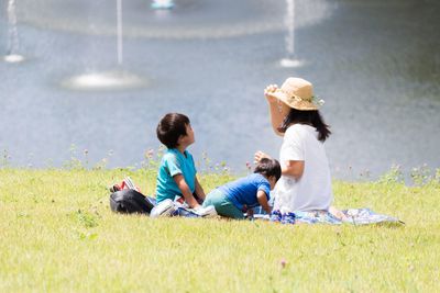 Boy sitting on grassy field
