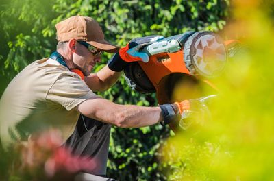 Man checking lawn mover in yard