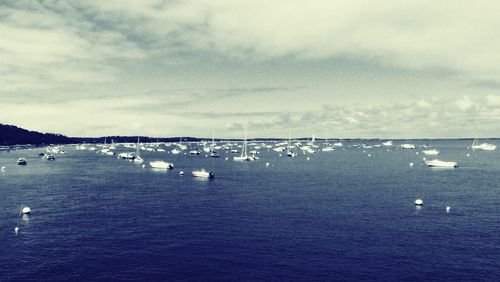 Sailboats in sea against sky