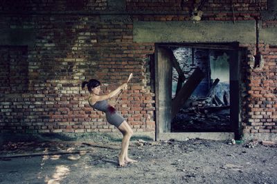 Full length of boy playing in brick wall