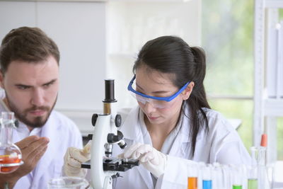 Scientists with microscope experimenting in laboratory 