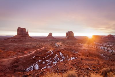 Rock formations on landscape against sky during sunset