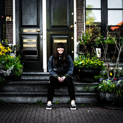 Full length portrait of woman sitting on steps