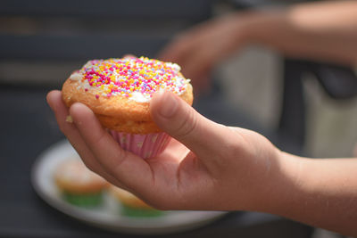 Close-up of hand holding muffin