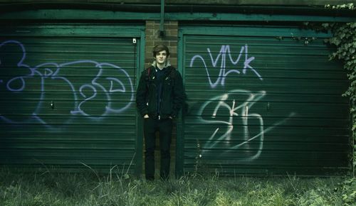 Full length of a man standing against yellow wall