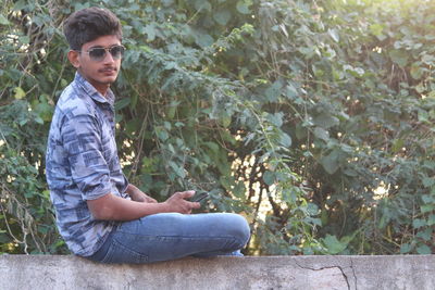 Young man sitting on plant