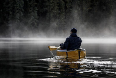 Rear view of man splashing in water