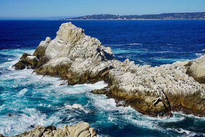 Scenic view of rocks in sea against sky