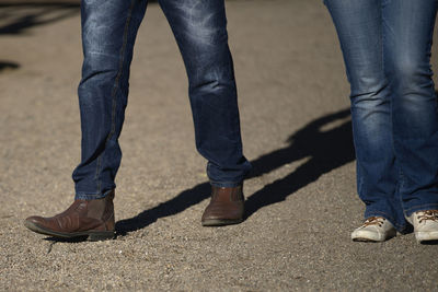 Low section of men standing on footpath