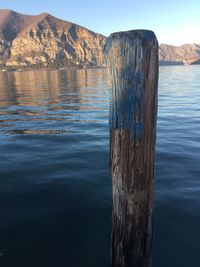 Wooden posts in lake against mountains